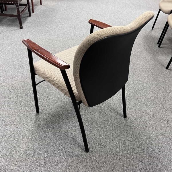 kimball mix-it tan upholstered seat, black legs, cherry veneer arm rests, seat back has a slight heart shape, back view, back is black plastic