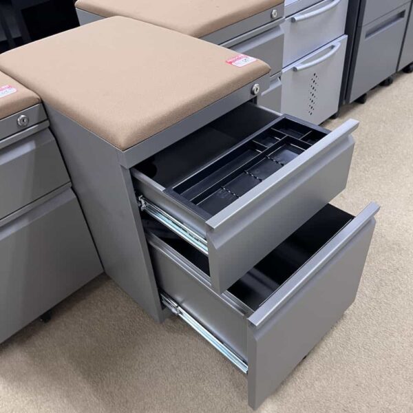 grey metal box file rolling with tan upholstered cushion on top