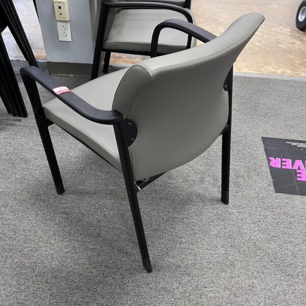 grey vinyl guest chair with black arms stackable 9 to 5 seating used furniture